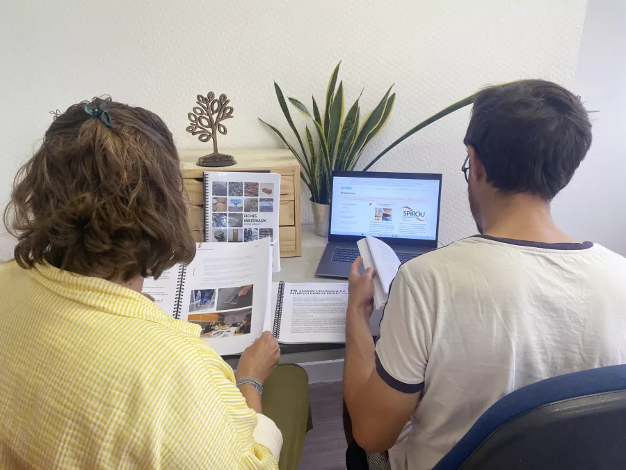 Deux personnes discutent avec des guides techniques à la main