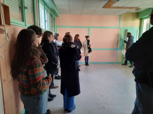 Un groupe de personnes dans un bâtiment regardent les matériaux réemployables